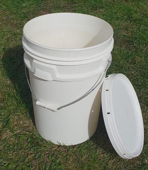 An empty bucket with a lid for making weed tea fertilizer